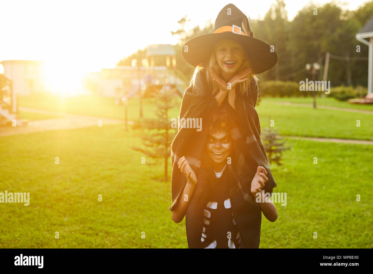 Portrait de deux petits enfants espiègles, garçon et fille, de s'amuser en plein air sur l'Halloween et faire des grimaces à la caméra à la fois, portant les costumes, copy space Banque D'Images