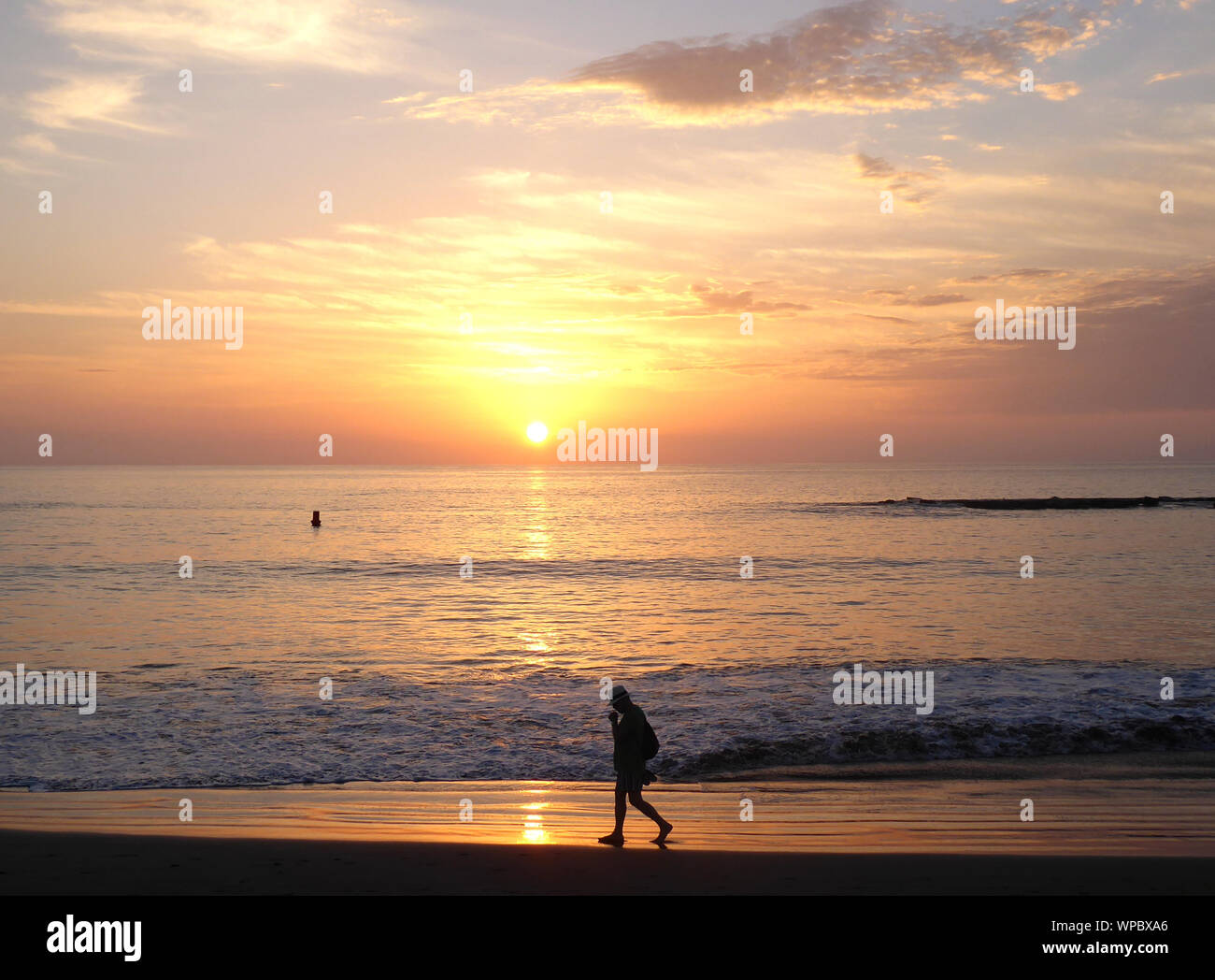 Homme marchant le long de plage au coucher du soleil à Ténérife Banque D'Images