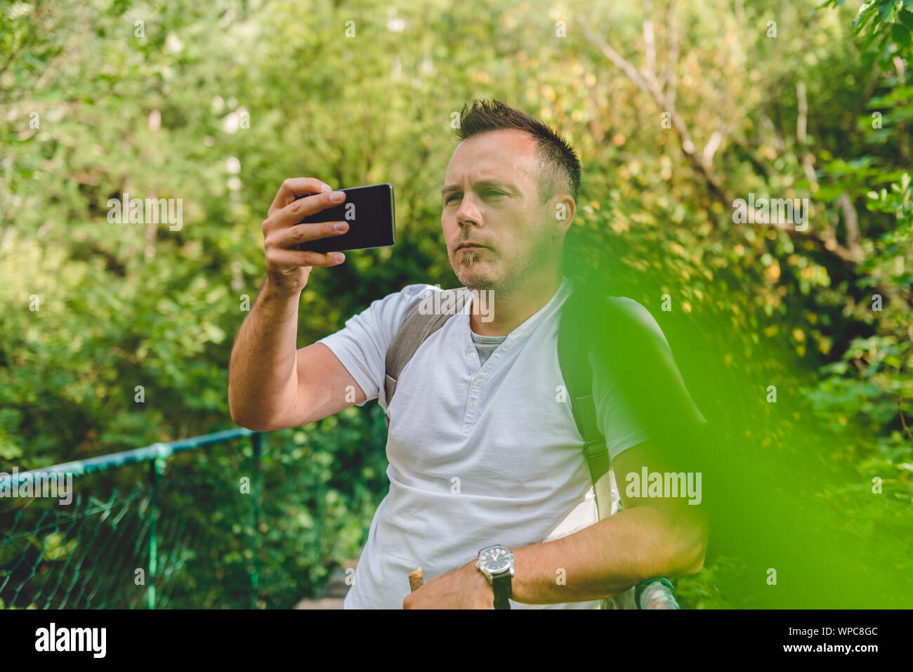 La prise de photo dans le randonneur vert forêt avec smart phone Banque D'Images
