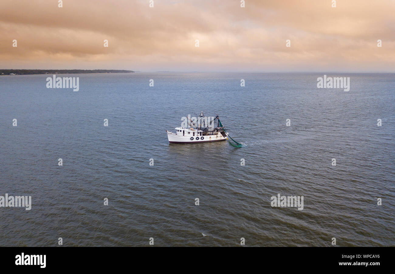Vue aérienne de crevettes voile au large de la côte de la Caroline du Sud, USA au lever du soleil. Banque D'Images