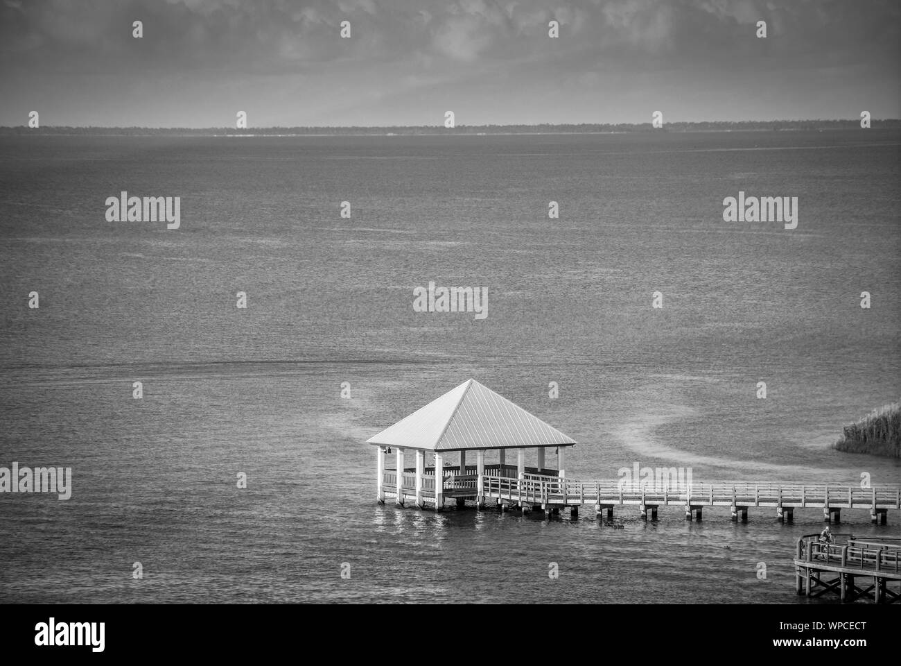 Ambiance éthérée de plate-forme avec toit propanel assis sur pilotis, entouré par l'eau avec une longue passerelle en bois sur la baie d'Apalachicola, en FL Banque D'Images