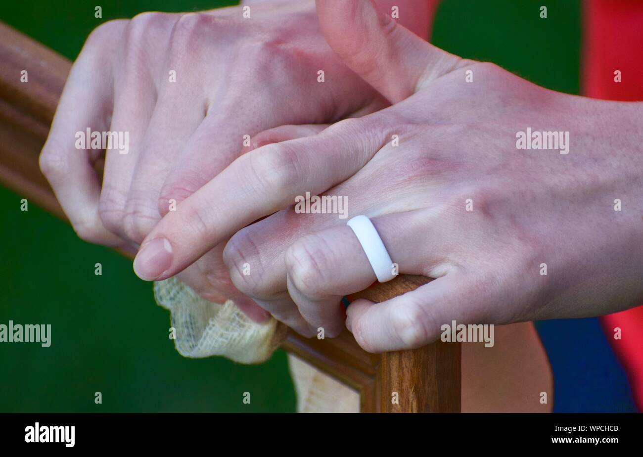 Le brossage à la main cadre en bois avec l'Atc chiffon contre une toile de fond herbeux. Bras blanc éliminant les particules- bague blanche en main Banque D'Images