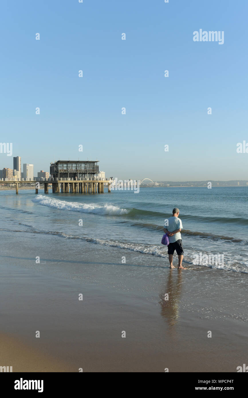 Durban, Afrique du Sud, seul adulte homme debout sur la plage à la recherche en distance, Ushaka jetty, paysage, arrière-plan, le mode de vie, matin, les gens, la ville Banque D'Images