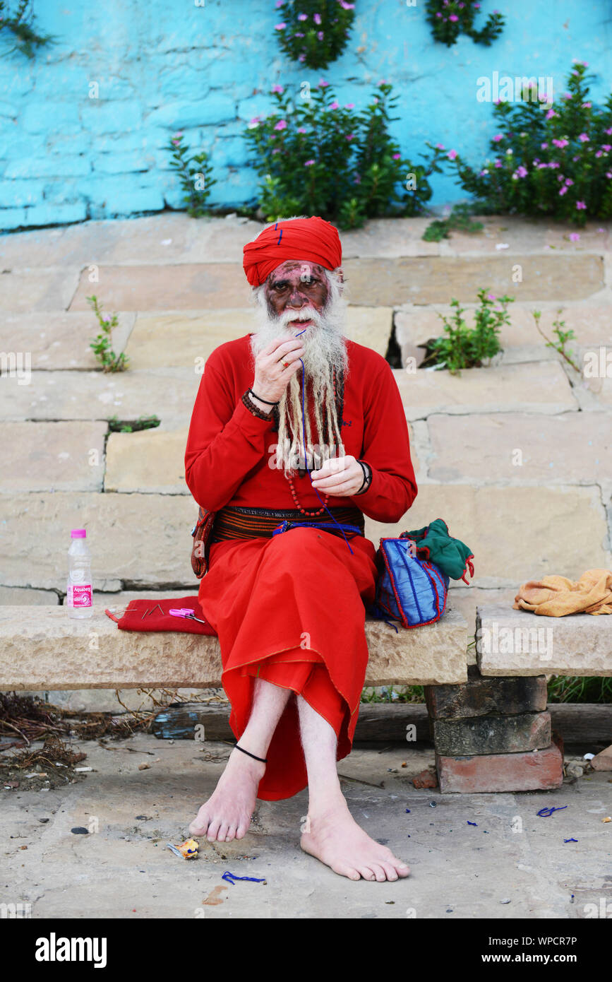 Un Sadhu albinos assis sur les ghats de Varanasi, Inde. Banque D'Images