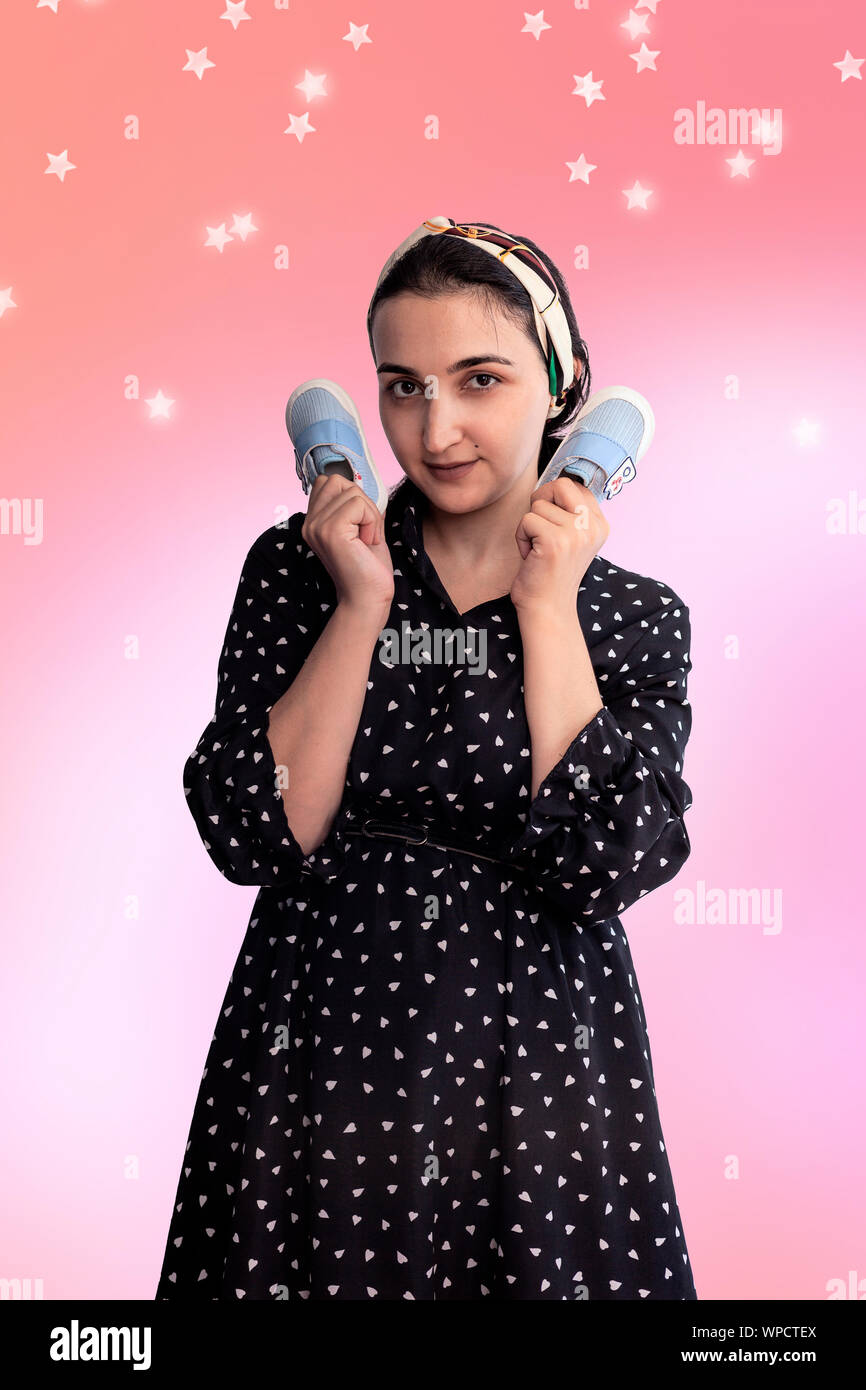 Femme Holding Baby Shoes Et Vous Pensez Avoir Un Bebe Jeune Femme Moyen Orientale Rever Un Enfant Maternite Soins Prenatals Attendez Un Bebe Photo Stock Alamy