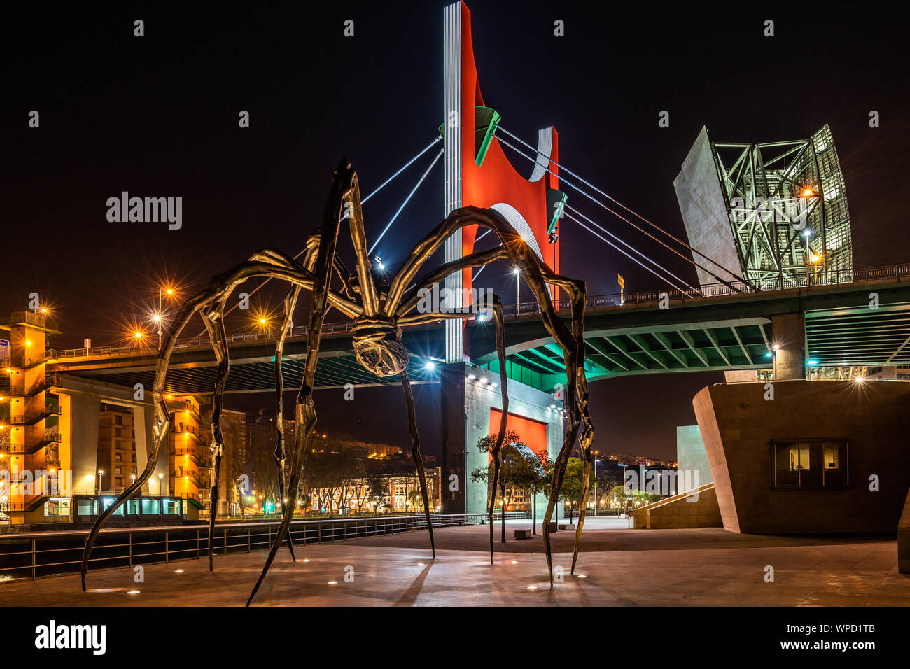 Vue de nuit de maman l'Araignée géante sculpture sur l'allée de Musée Guggenheim avec pont de La Salve dans l'arrière-plan, Bilbao, Pays Basque, Espagne Banque D'Images