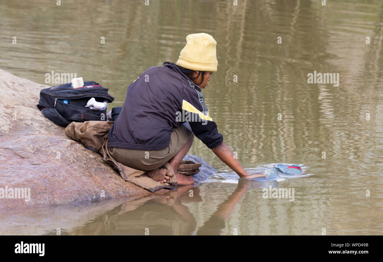 Méconnaissable femme faire la lessive dans une rivière, à Madagascar Banque D'Images