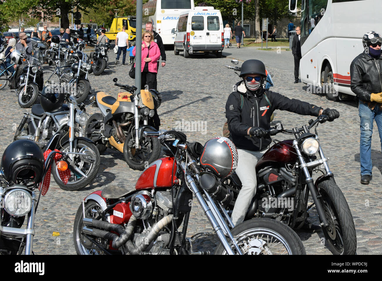 Tampere, Finlande - le 31 août 2019 : Beaucoup de motos en stationnement. Biker portant un masque de visage et en regardant la caméra. Banque D'Images