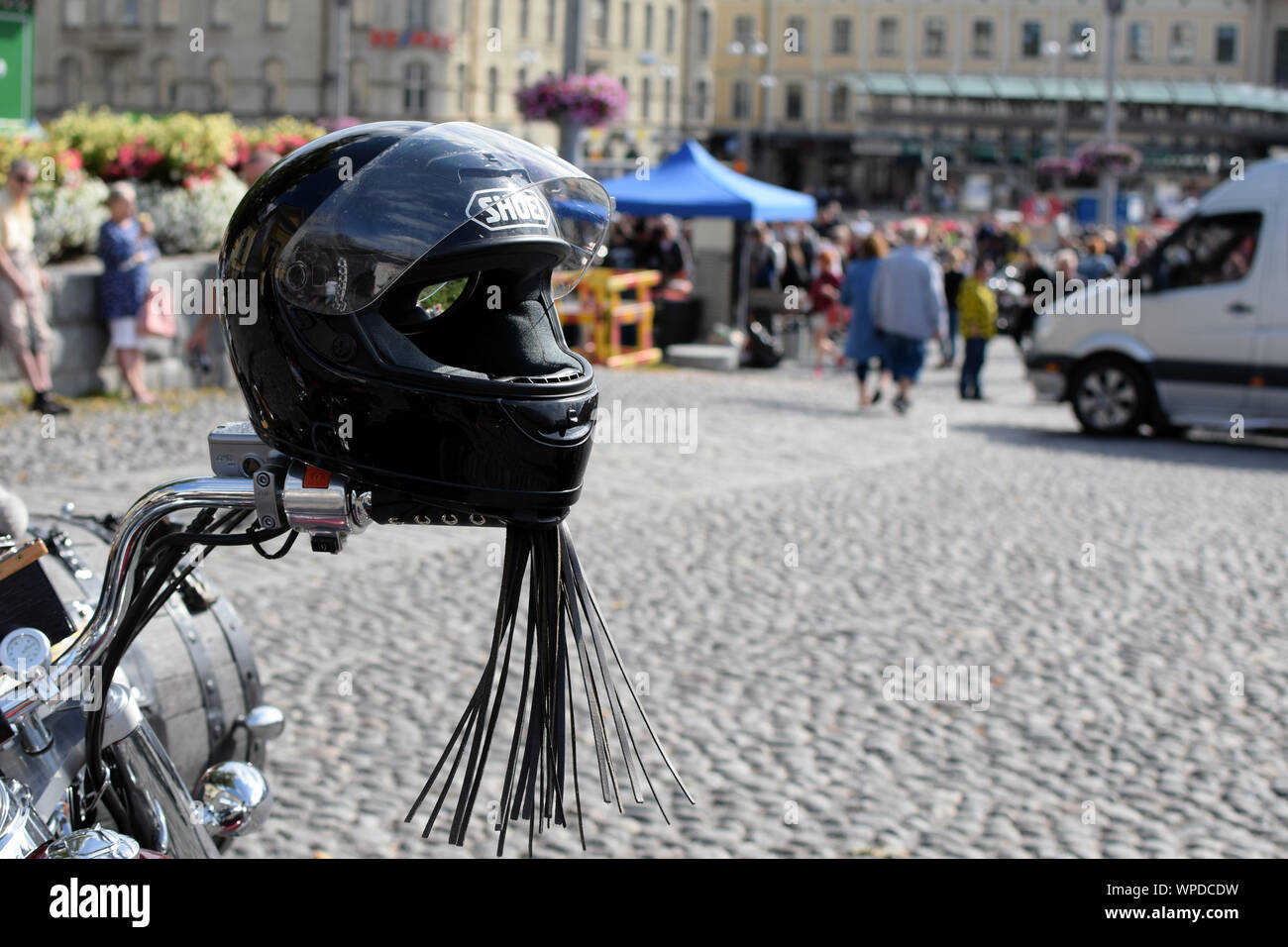 Casque Shoei noir sur guidon moto. Arrière-plan flou. L'espace pour le texte. Banque D'Images