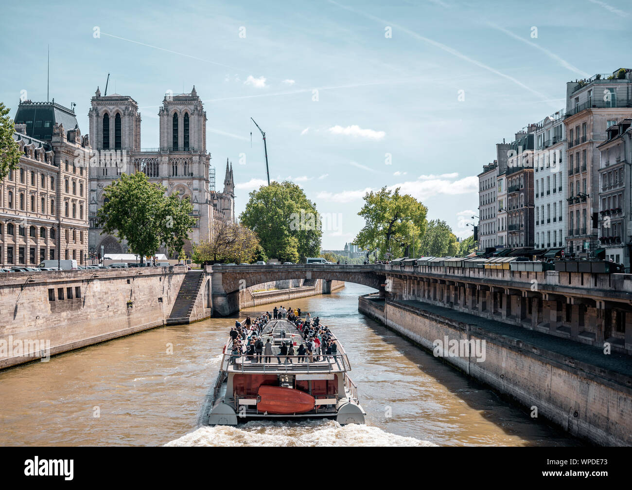 Un bateau de plaisance avec les touristes à bord effectue une excursion guidée de la Seine dans le Paris historique avec vue sur la cathédrale Notre Dame une Banque D'Images