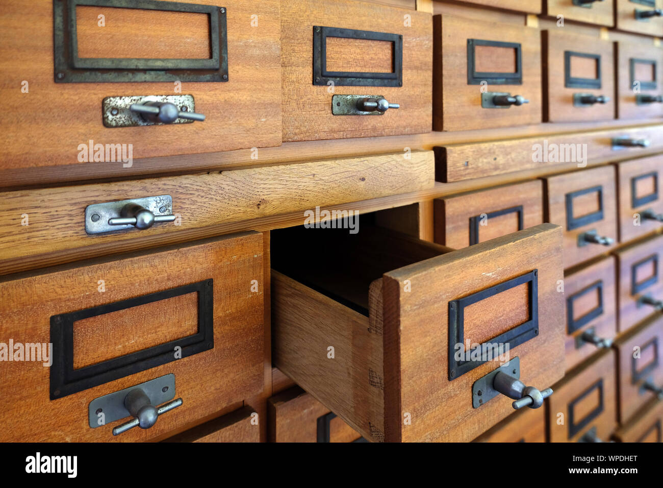 Classeur vintage en bois avec de nombreux tiroirs pour organiser  l'archivage. Un tiroir ouvert Photo Stock - Alamy