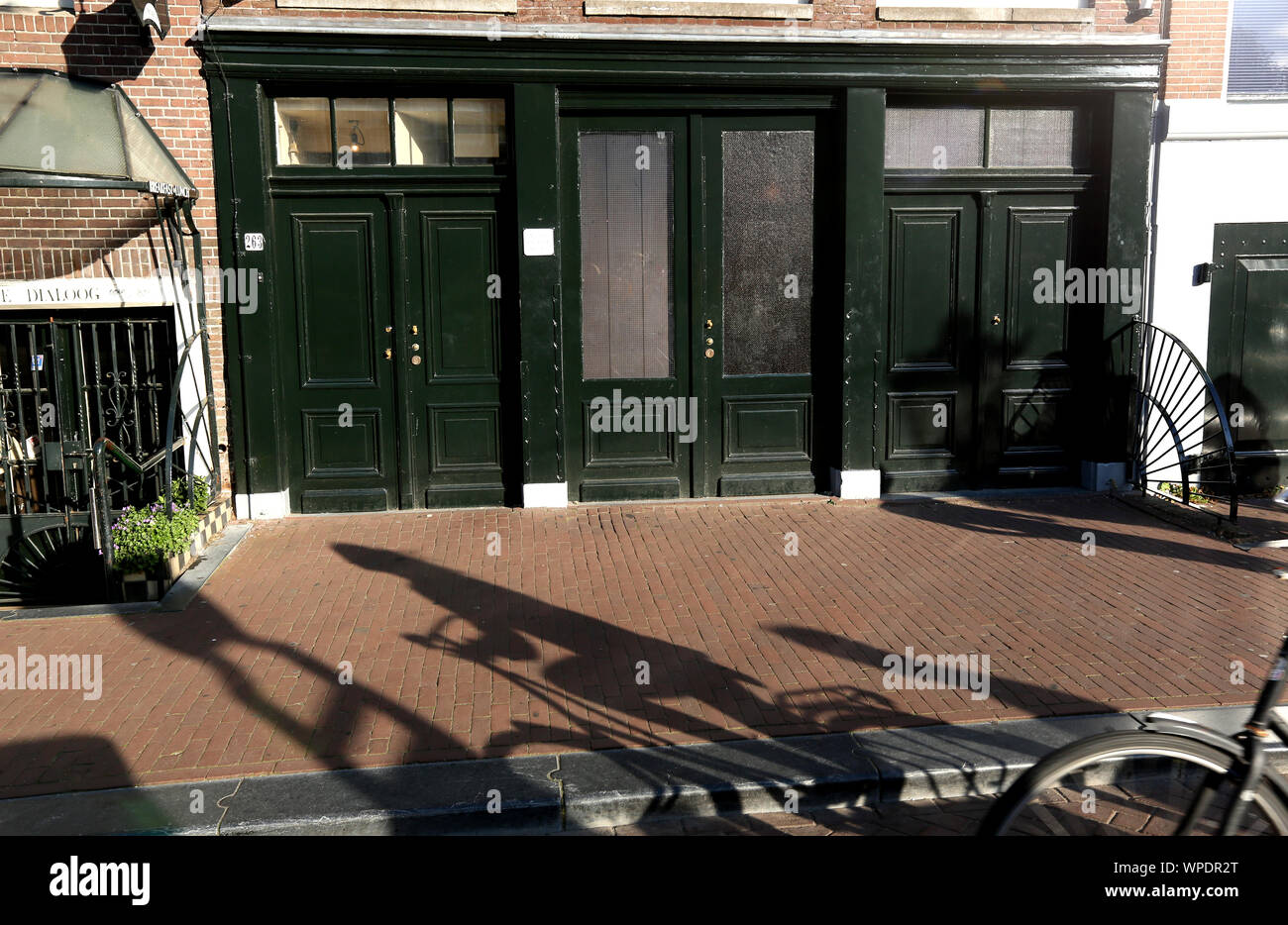 Une ombre d'un coureur passé équestre l'historique de la maison d'Anne Frank au 263 Prinsengracht, Amsterdam, Hollande. Banque D'Images