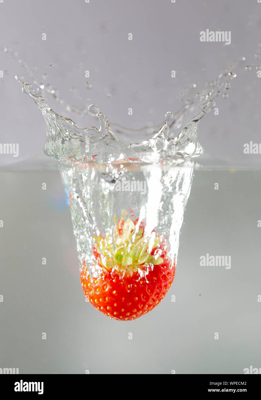 Gouttes dans l'eau de fraise Banque D'Images