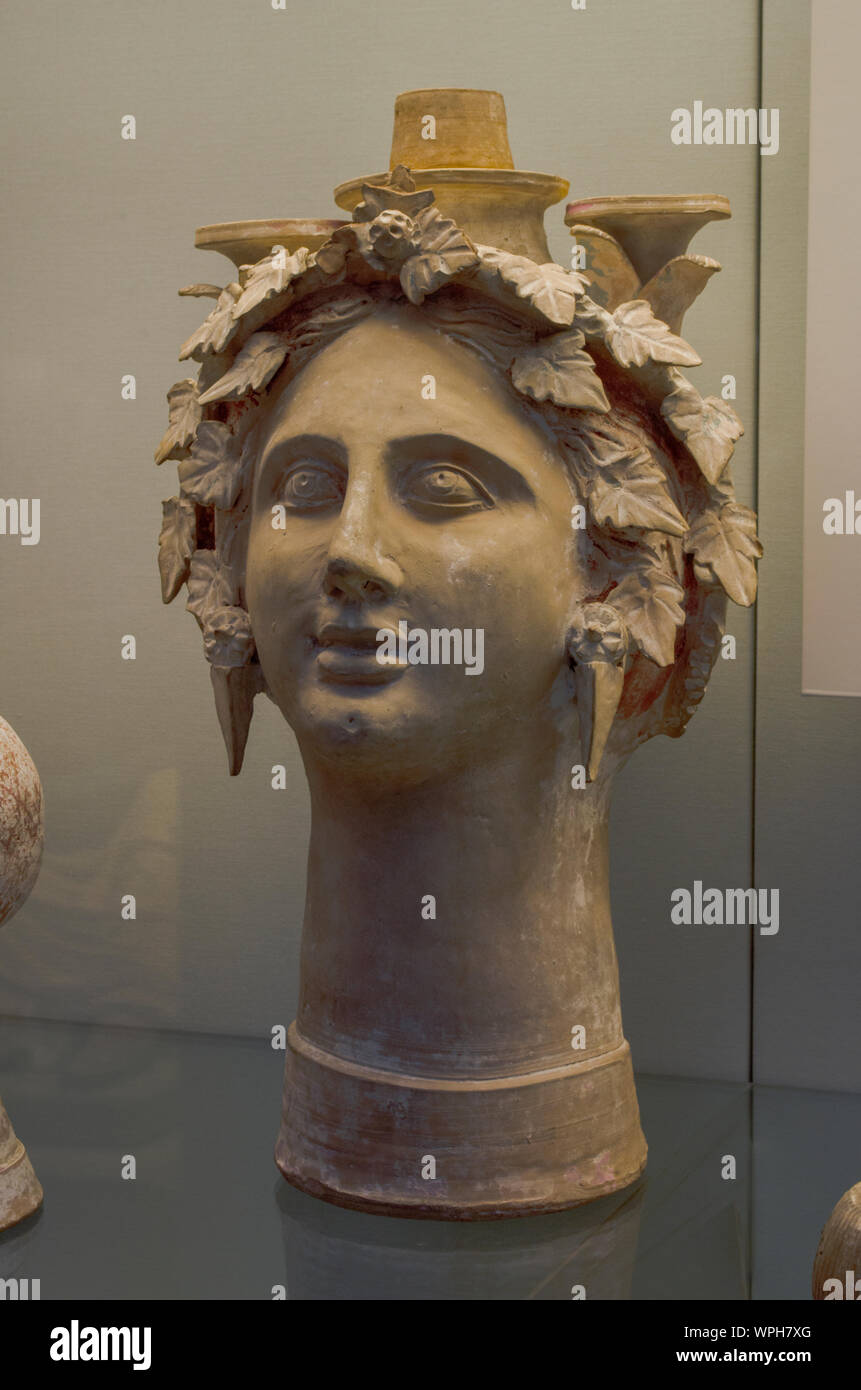 Tête de femme en terre cuite avec d'oreilles et guirlande de feuilles de lierre, partiellement imitant un vase (lekythos). Les trois colonnes ci-dessus s'est tenue une fois compris atta Banque D'Images