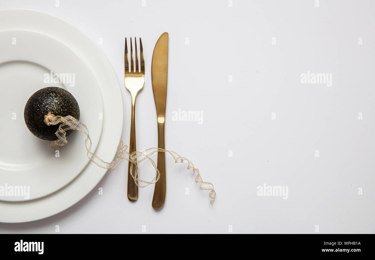 Table de dîner de Nouvel An, Boule de Noël avec le ruban et couverts sur l'ensemble de la vaisselle blanche, fond blanc, vue du dessus Banque D'Images