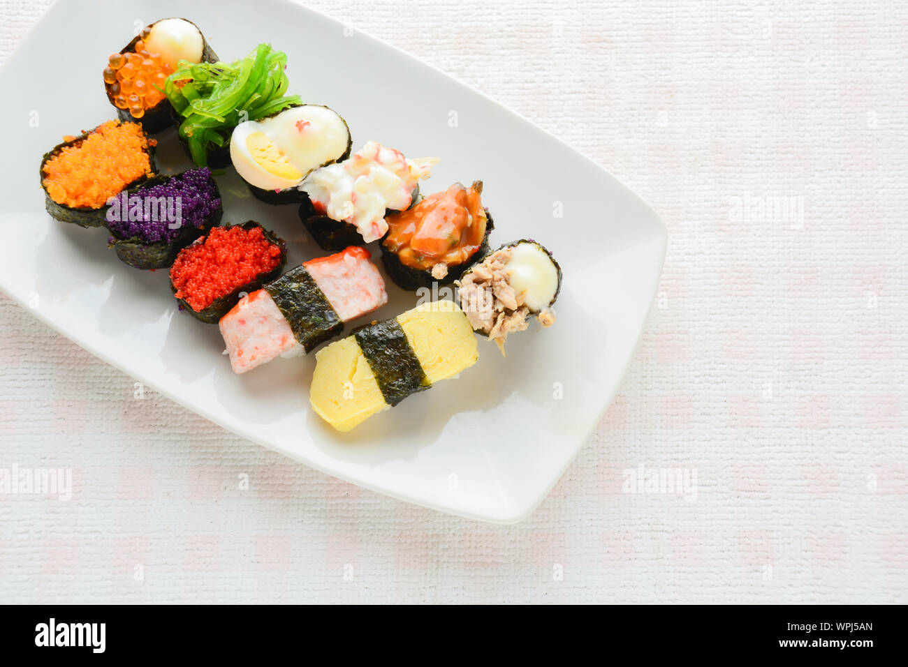 Sushi sur plaque blanche, thon, saumon, loup de mer, crevettes, oeufs sucrés sushi, cuisine japonaise Banque D'Images