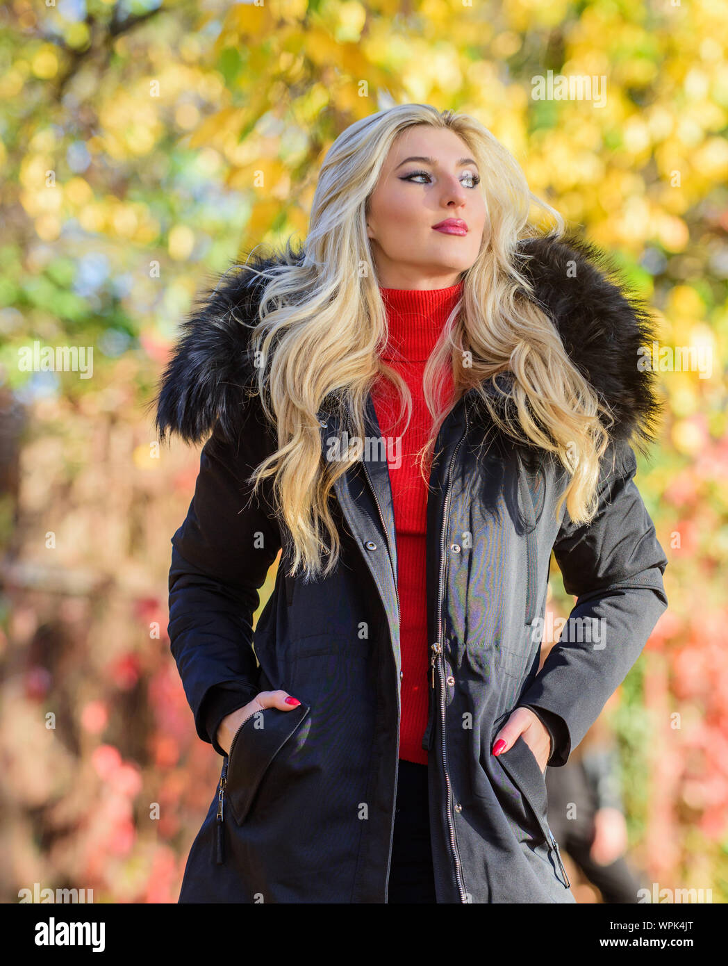 Création d'automne tenue de se sentir à l'aise et jolie. Tenue moderne pour  les jeunes. Fille dans un manteau en position park nature fond flou. Femme  de longs cheveux blonds porter des