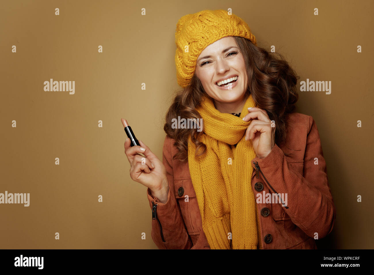 Bonjour l'automne. Portrait of happy femme moderne en béret et écharpe jaune  avec le rouge à lèvres d'hygiène contre l'arrière-plan de bronze Photo  Stock - Alamy