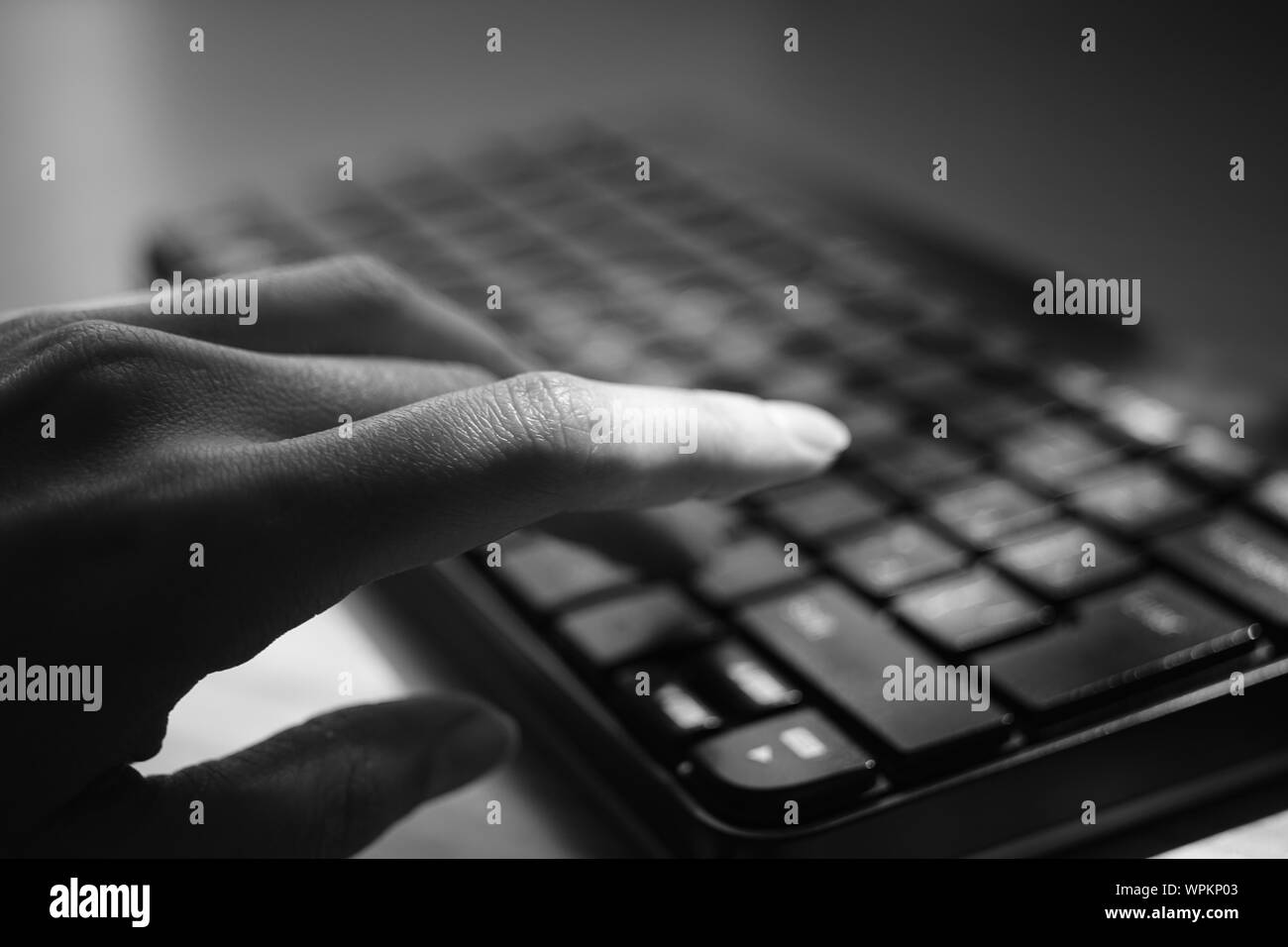 La femelle est saisie au clavier, selective focus sur le doigt, photo en noir et blanc. Banque D'Images
