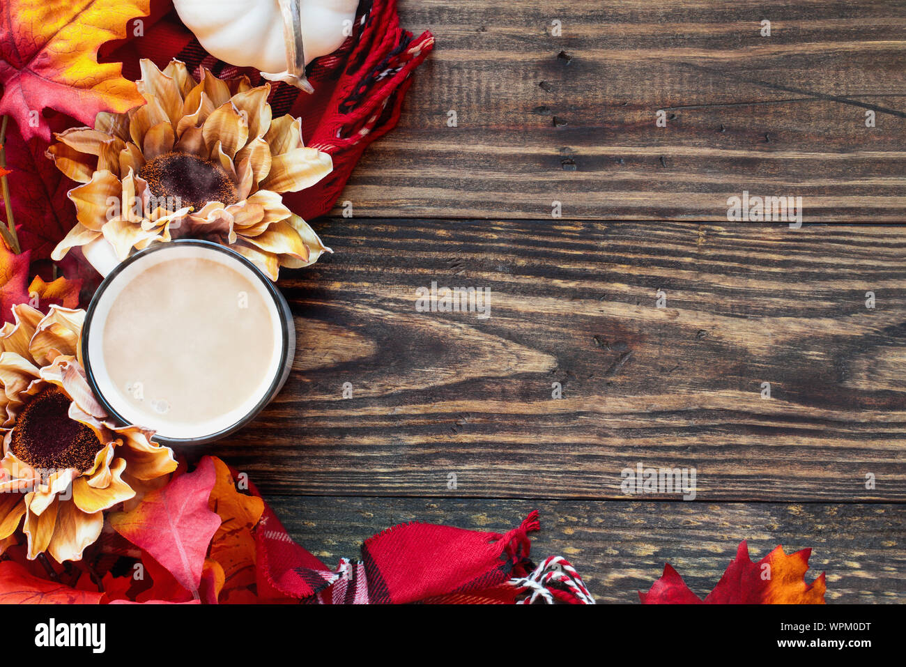 Délicieux chaud, tasse chaude ou grande tasse de café avec de la crème sur une table en bois rustique et entouré d'arrière-plan, les feuilles d'automne, fleurs rouge foulard à carreaux Banque D'Images