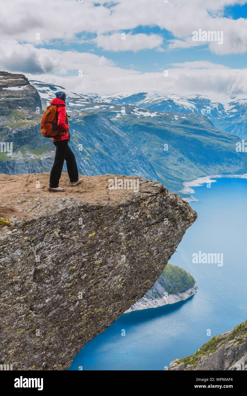 Sporty woman posing sur Trolltunga. Superbdevotie profiter du magnifique lac et de beau temps en Norvège. Banque D'Images