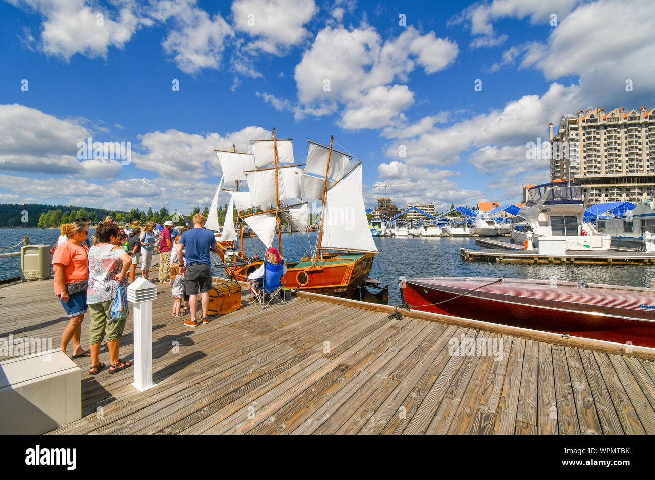 Les visiteurs du Coeur d'Alene Wooden Boat Show parler avec un propriétaire de bateau habillé en pirate sur sa réplique miniature bateau amarré à la marina Banque D'Images