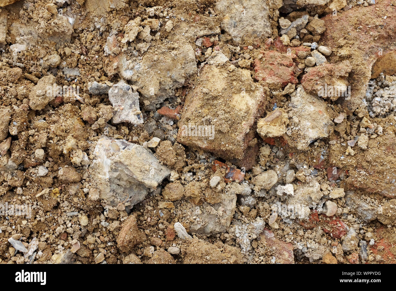 Les pièces de béton et de brique, mélangé avec le sol et les pierres d'une excavation - texture de fond abstrait Banque D'Images