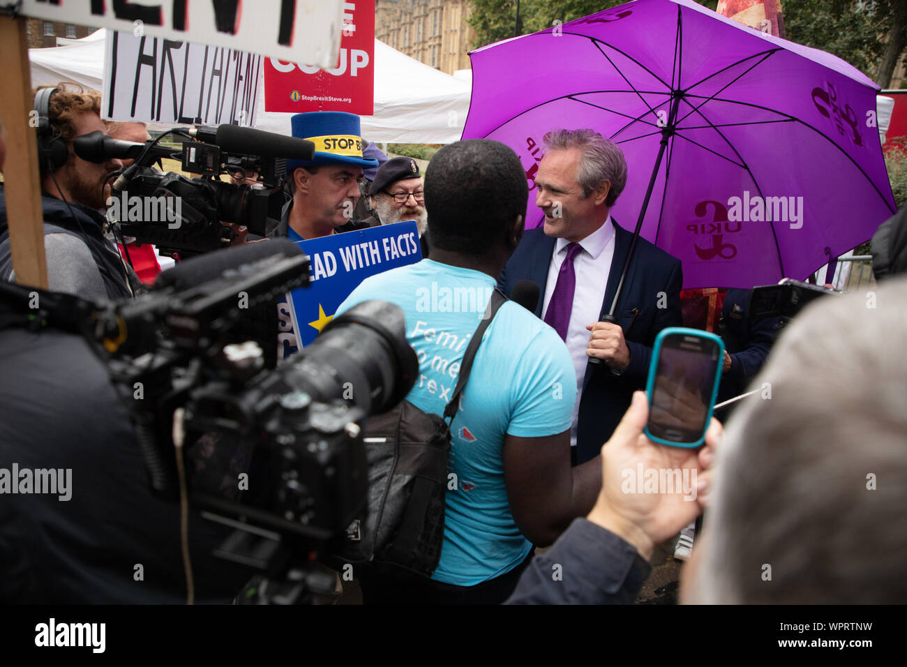 Londres, Royaume-Uni. 9 Septembre, 2019. Richard Braine, le chef de l'UKIP en Grande-Bretagne (UK Independence Party) représenté sur College Green en face les maisons des Communes avec un parapluie violet et en parlant à un membre de la presse, sous l'oeil de Steve Bray ou Mr Arrêter Brexit. Crédit : Joe Keurig / Alamy News Banque D'Images Londres, Royaume-Uni. 9 Septembre, 2019. Richard Braine, le chef de l'UKIP en Grande-Bretagne (UK Independence Party) représenté sur College Green en face les maisons des Communes avec un parapluie violet et en parlant à un membre de la presse, sous l'oeil de Steve Bray ou Mr Arrêter Brexit. Crédit : Joe Keurig / Alamy News Banque D'Images