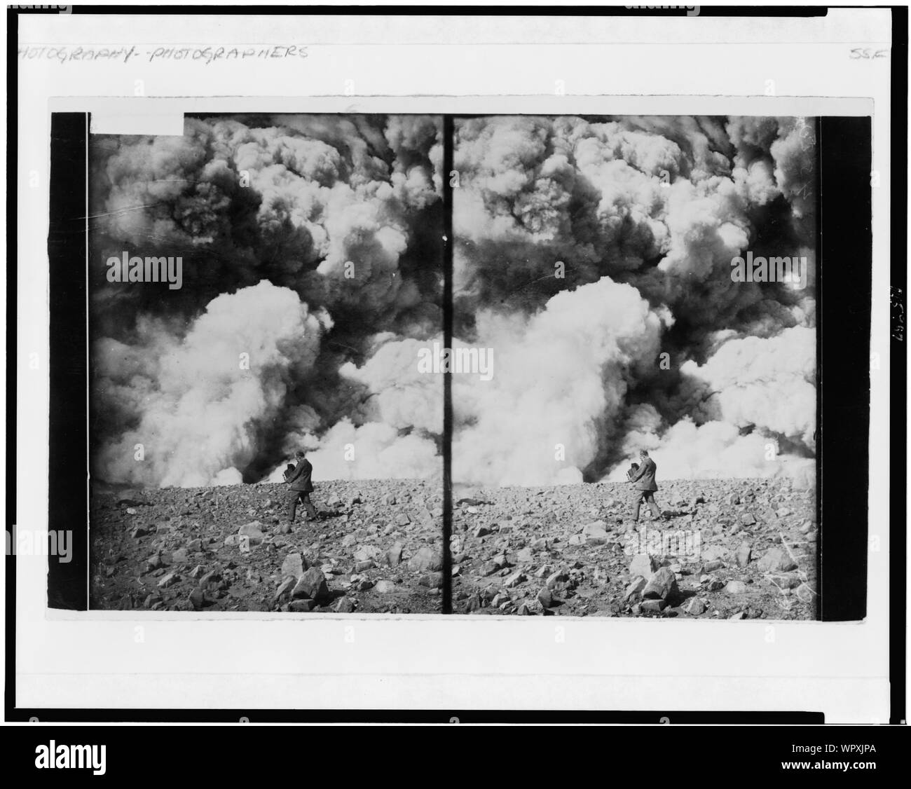 Man holding grand appareil photographier un événement cataclysmique, peut-être un volcan en éruption Banque D'Images