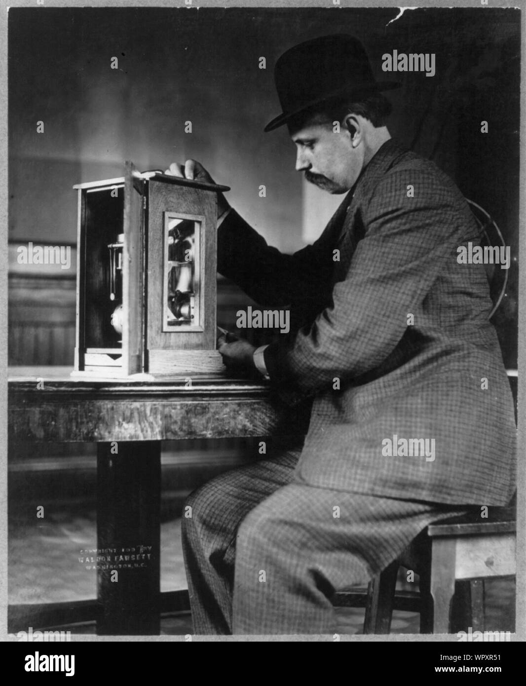 Homme assis avec un distributeur automatique de timbres Banque D'Images