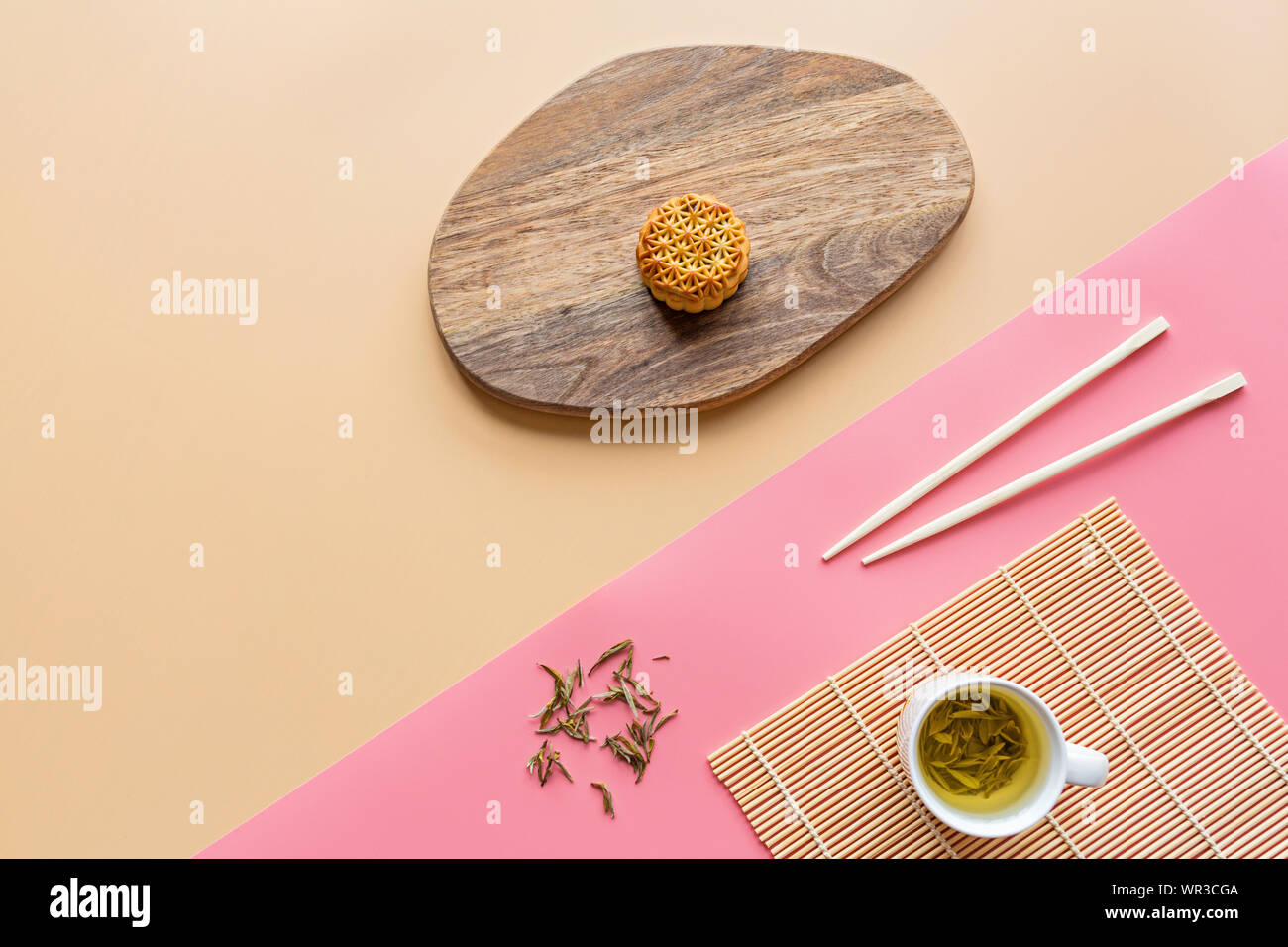 Mise à plat de dessert Festival chinois, Festival de mi-automne de gâteau de lune sur fond coloré avec du thé vert et de baguettes. Vue de dessus, copiez l'espace, immersive Banque D'Images