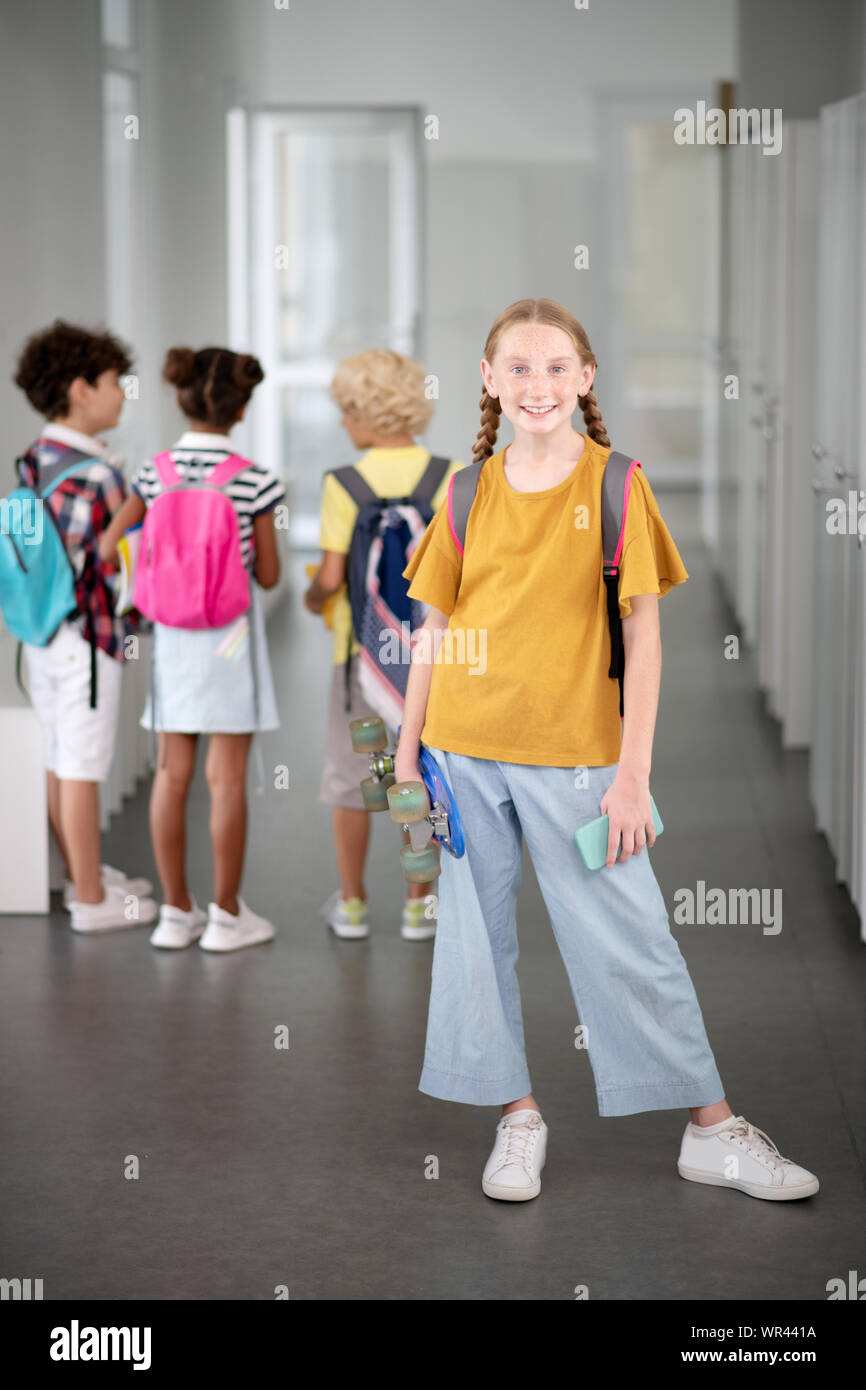 La tenue d'écolière élégant smartphone et Penny Banque D'Images