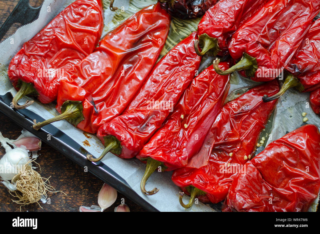 Poivrons rouges rôtis préparation pour l'hiver sur la table en bois. Banque D'Images