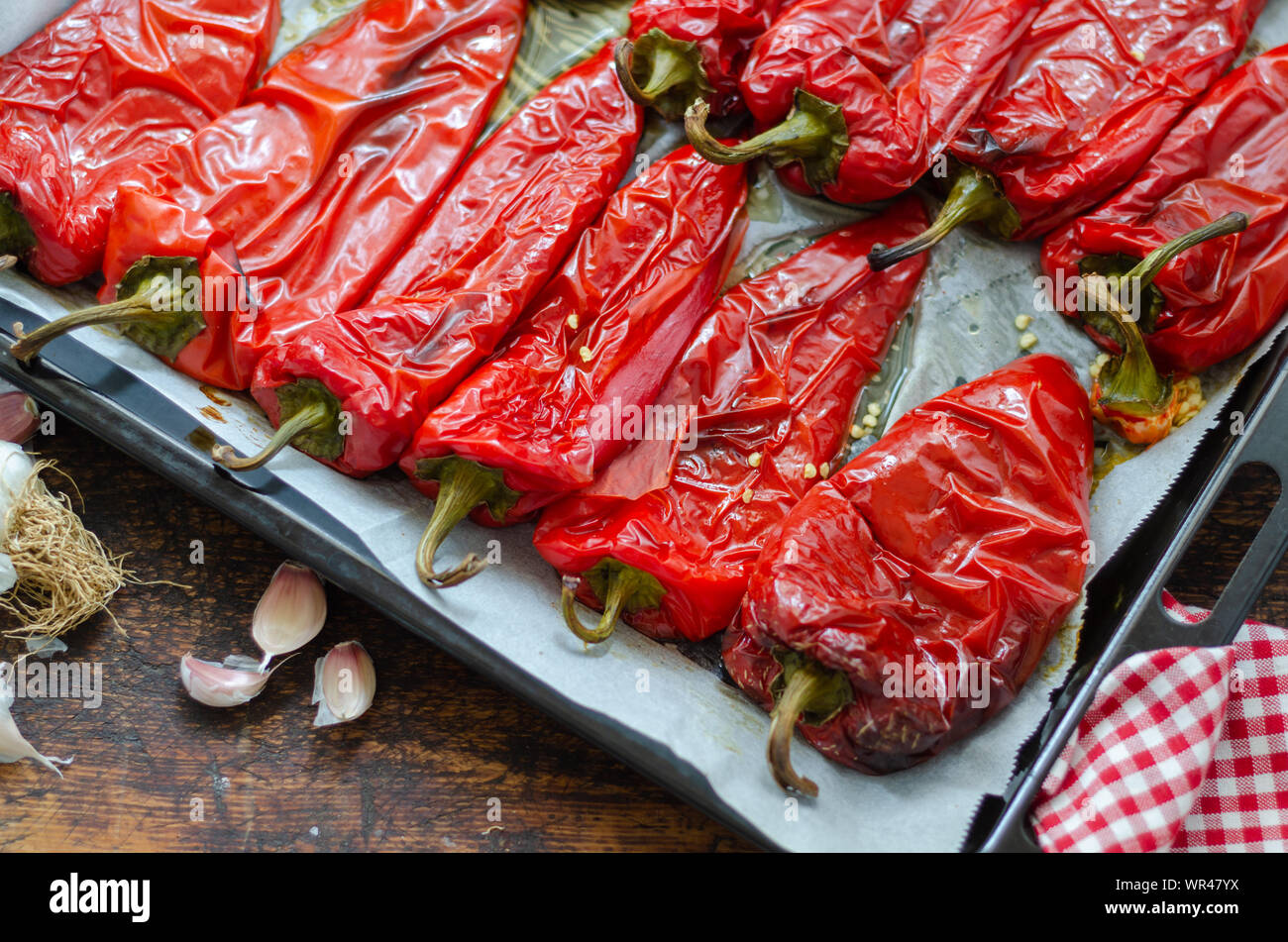 Poivrons rouges rôtis préparation pour l'hiver sur la table en bois. Banque D'Images