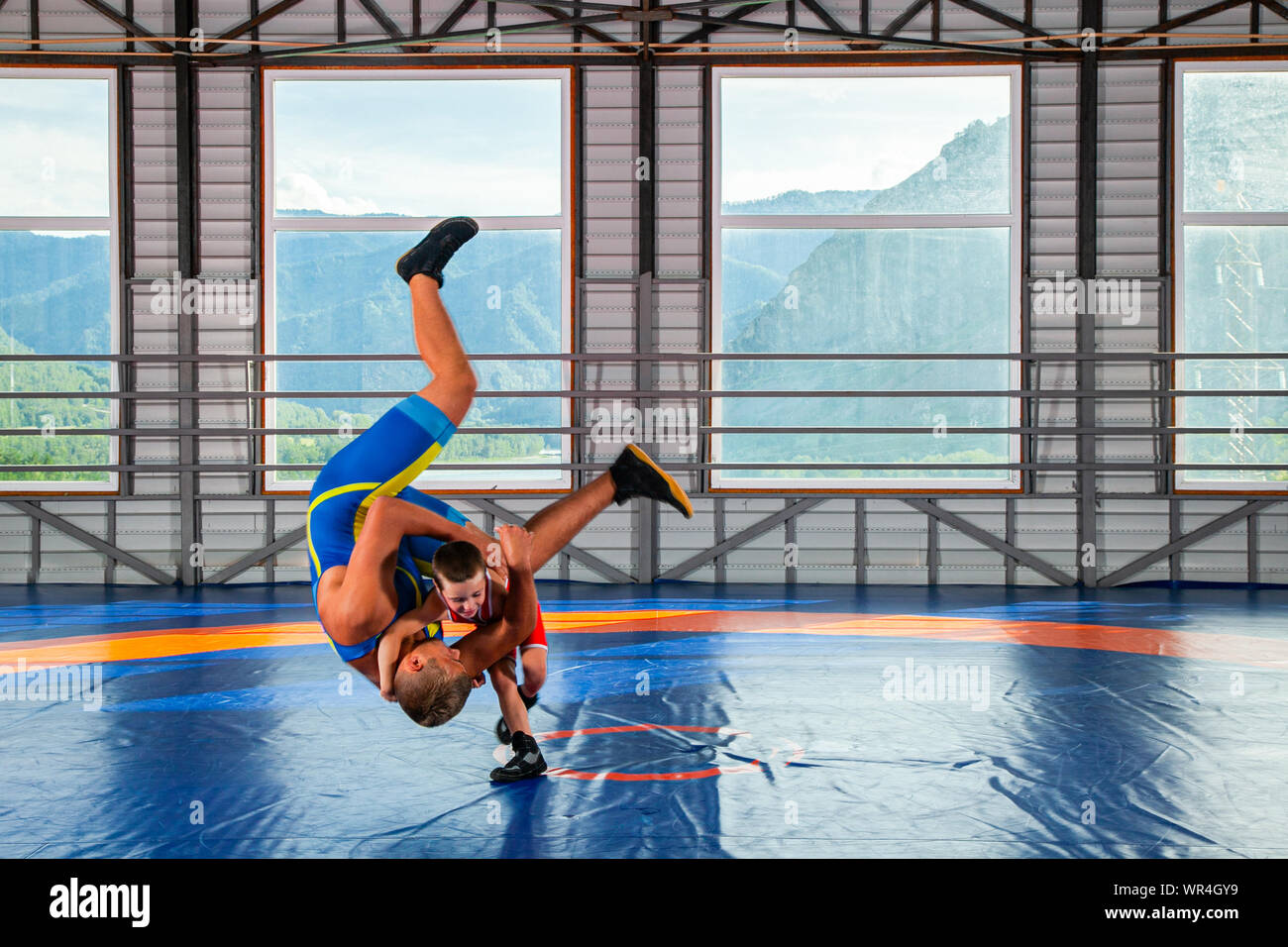 Un lutteur boy dans un collant de sport se débat avec un homme adulte  wrestler sur un tapis de lutte dans la salle de sport. Le concept de  l'alimentation de l'enfant et