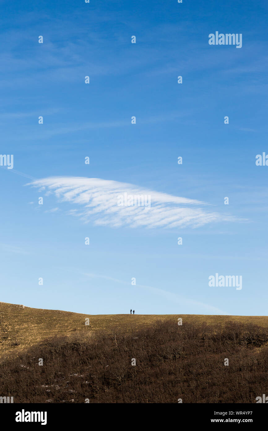 Deux personnes sur un pic de montagne avec un nuage au-dessus d'eux Banque D'Images
