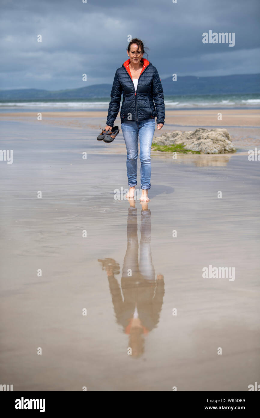 Chaussures femme marchant pieds nus sur la plage de Benone, Coleraine, en  Irlande du Nord, Royaume-Uni Photo Stock - Alamy