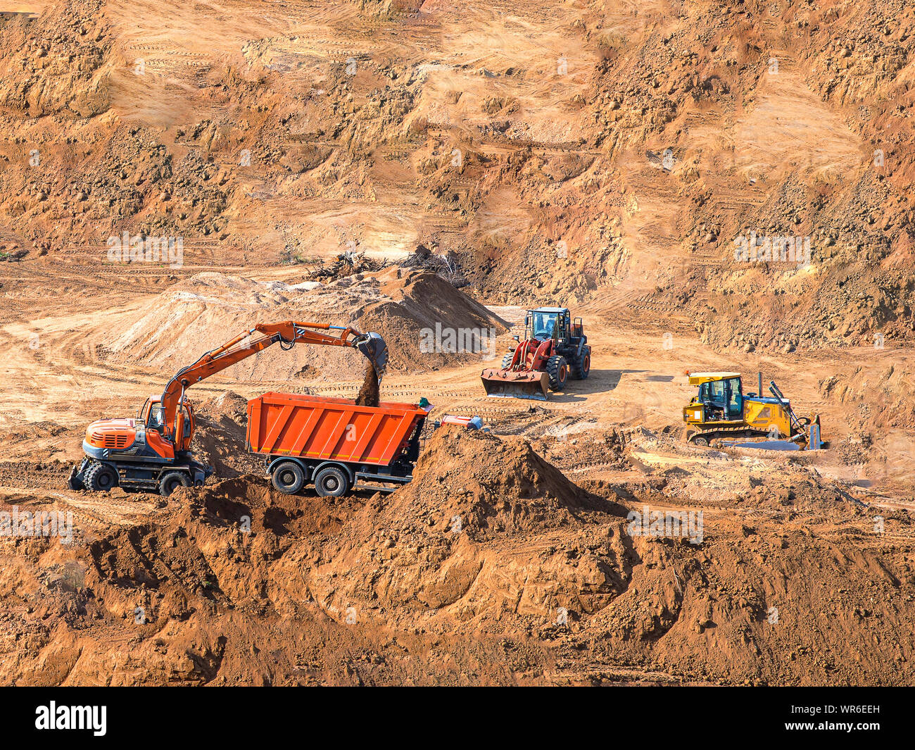 Chargeur pelle chargement machine camion dumper at construction site. digger chargeur sur roues et d'équipement de construction lourde stationné au bac à sable. Banque D'Images