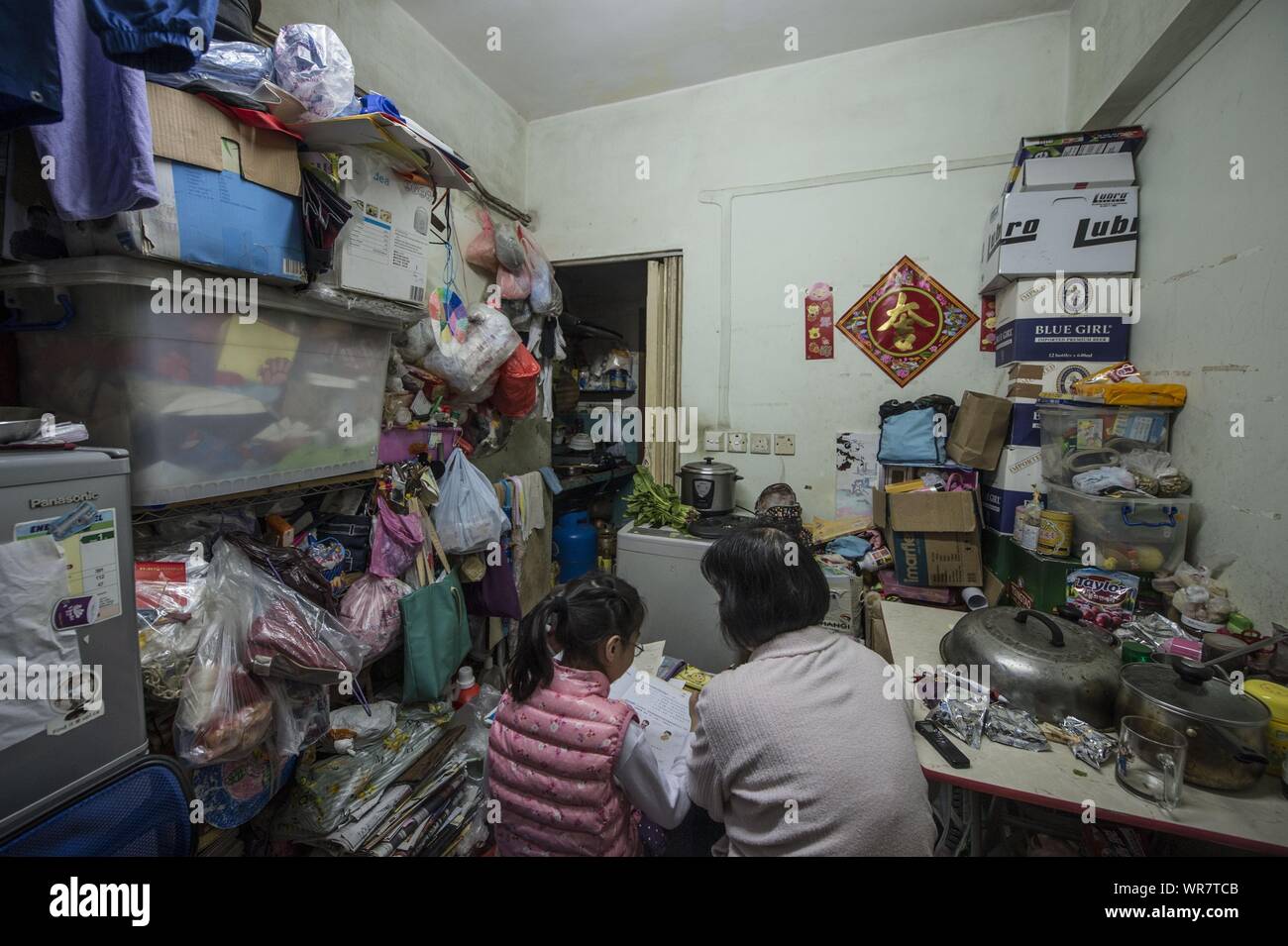 (190910) -- HONG KONG, le 10 septembre 2019 (Xinhua) -- une femme sa fille tuteurs lors d'une unité de location répartis sur 20 mètres carrés dans la région de Sham Shui Po, du sud de la Chine, Hong Kong, le 19 janvier 2016. (Xinhua) Banque D'Images