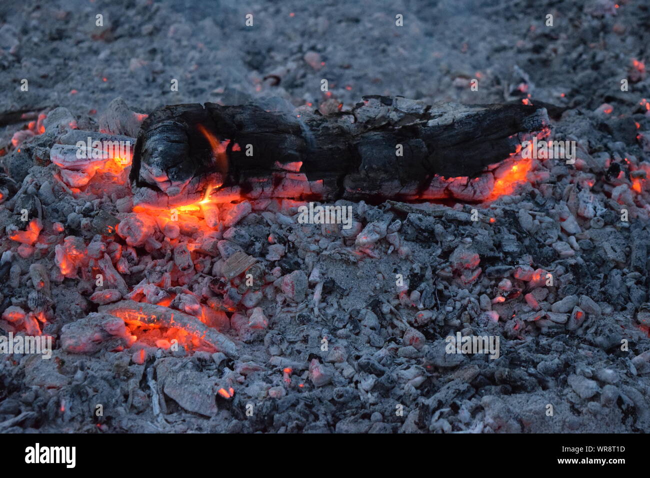 Connecter les braises d'un feu, toujours illuminées par la chaleur de l'incendie. Banque D'Images