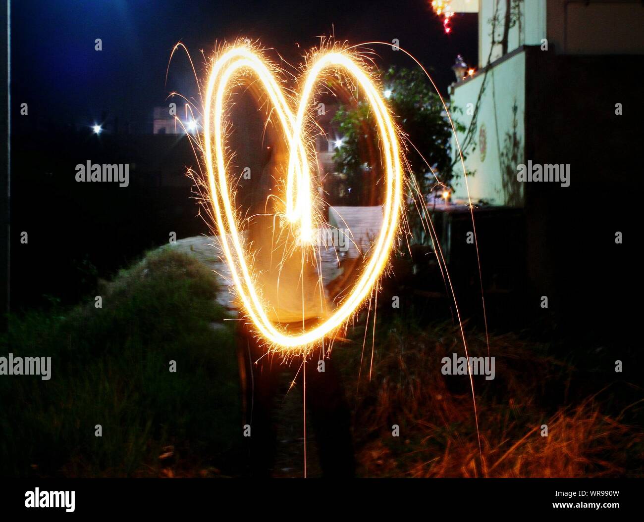 Forme de coeur formé de Burning Sparkler la nuit Banque D'Images