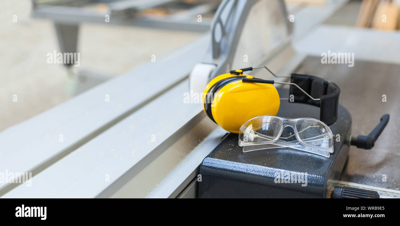 Des lunettes de sécurité au travail et de protection de l'ouïe sur scie circulaire à l'atelier, le volume, la protection des yeux Banque D'Images
