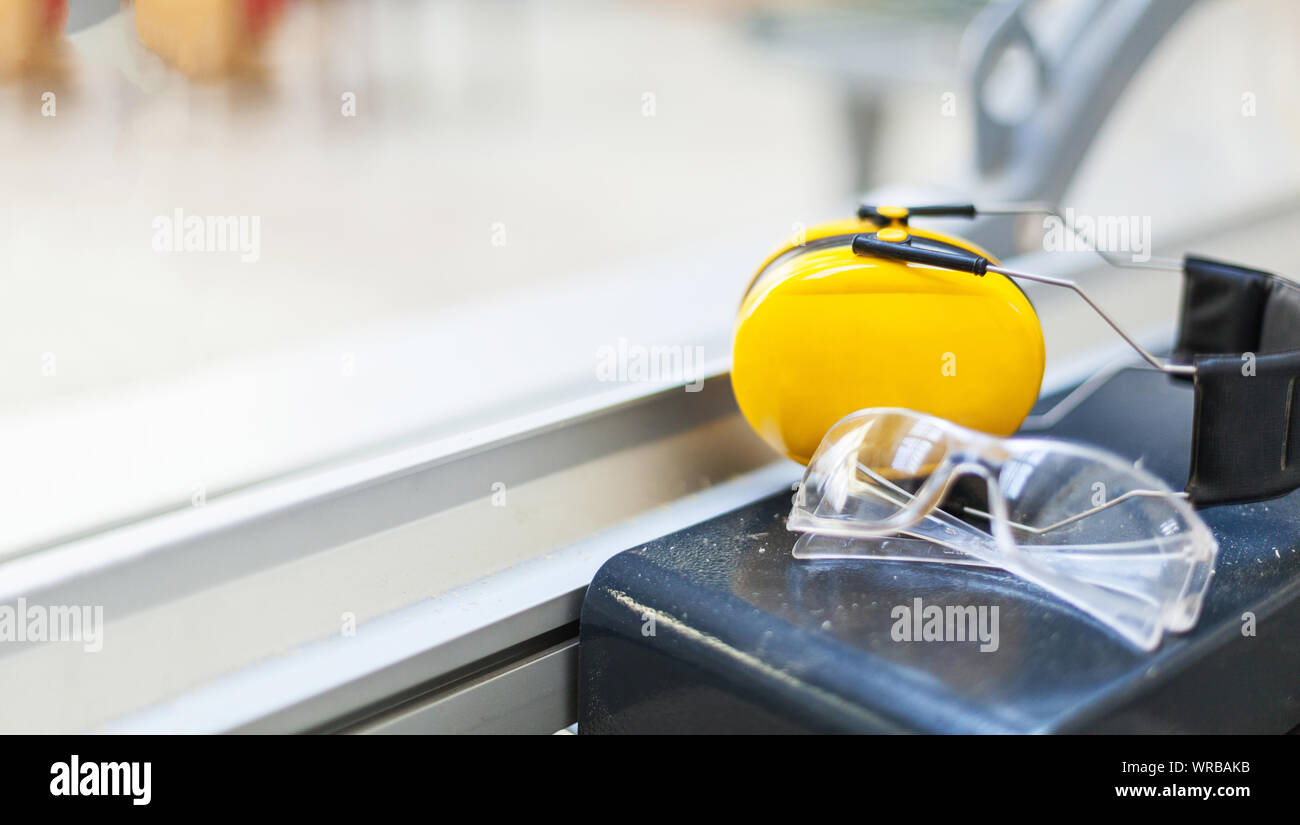 Des lunettes de sécurité au travail et de protection de l'ouïe sur scie circulaire à l'atelier, le volume, la protection des yeux Banque D'Images