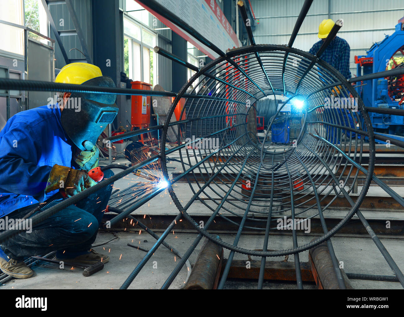 Les travailleurs d'usine chinois souder une cage d'armature en acier d'armature à une usine à Taicang City, Jiangsu Province de Chine orientale, Juillet 24th, 2019. China's dome brut Banque D'Images