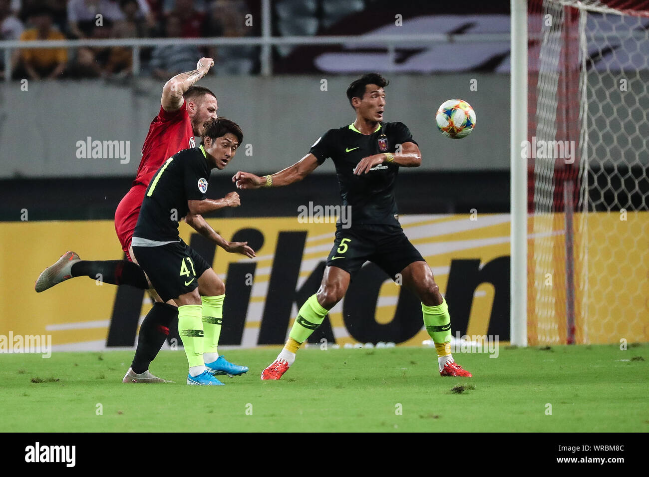 Marko Arnautovic, gauche, d'EPOP Shanghai défis Takahiro Sekine, centre, et Tomoaki Makino de Urawa Red Diamonds lors de leur premier match de la Banque D'Images