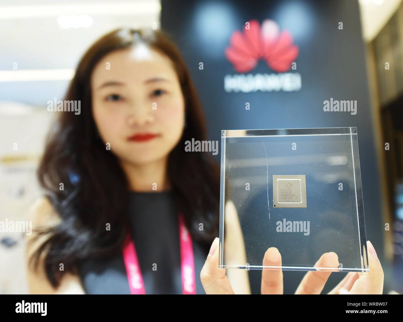 Une hôtesse chinoise montre une cinquième génération de lecteur à état solide (SSD) puce de commande de Huaweii lors de la 2e monde de la mémoire Flash (FMW) 2019 à Hangzhou Banque D'Images