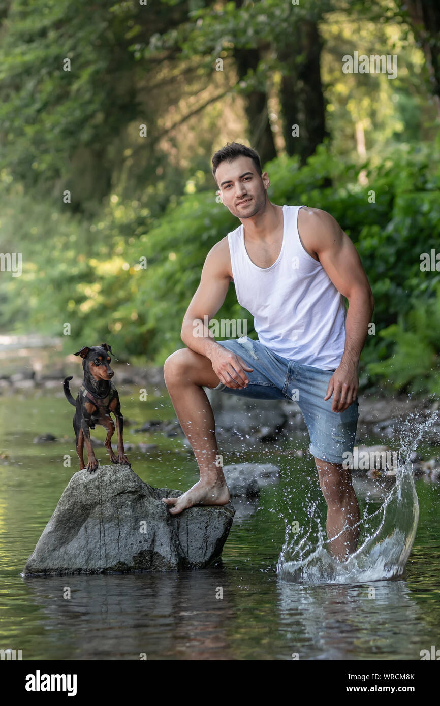 Close-up portrait of handsome young man with dog, extérieur. Banque D'Images