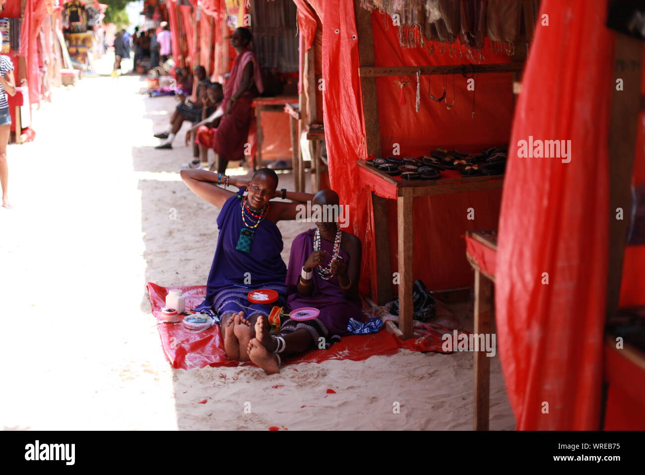 Masaï d'Afrique de faire une pause sur une chaude journée de janvier à partir de son travail de routine sur le tissage bracelets de perles. Banque D'Images Masaï d'Afrique de faire une pause sur une chaude journée de janvier à partir de son travail de routine sur le tissage bracelets de perles. Banque D'Images