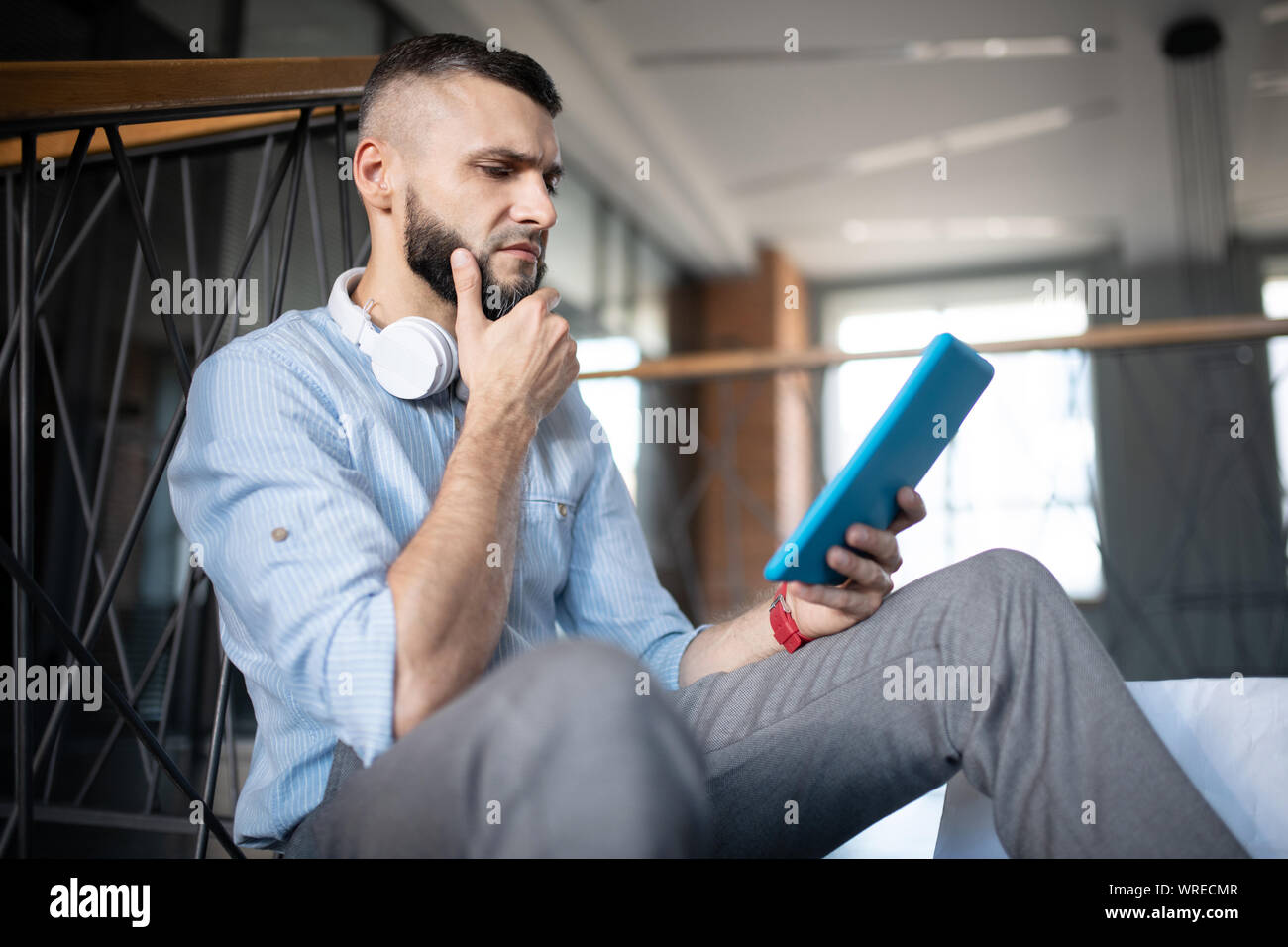 Homme barbu se sentir concerné lors de la lecture des nouvelles financières Banque D'Images