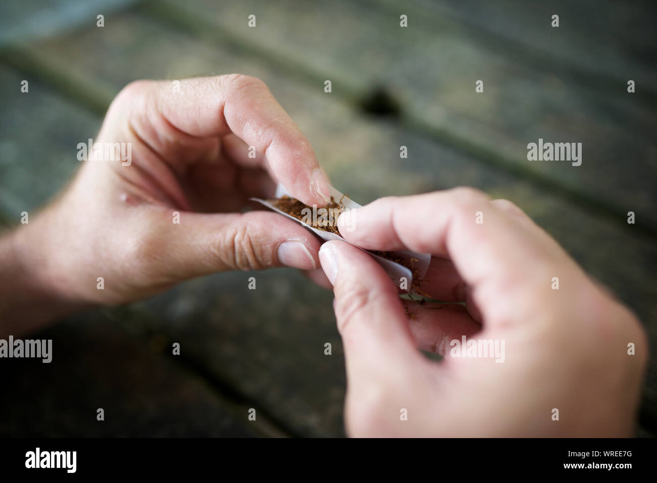 Les mains d'un homme roulant une cigarette Banque D'Images Les mains d'un homme roulant une cigarette Banque D'Images